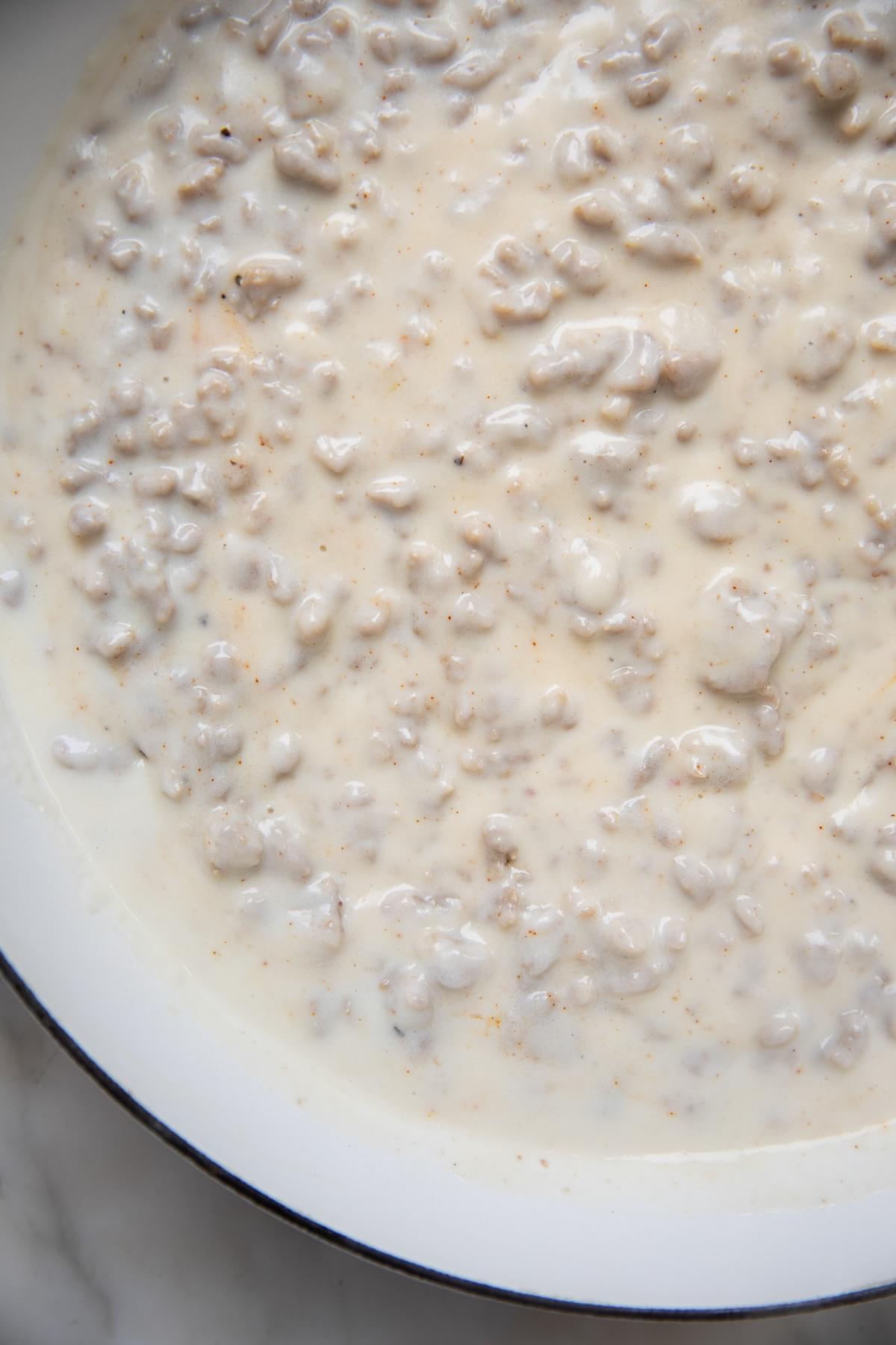 homemade sausage gravy in a skillet on the counter for biscuits and gravy