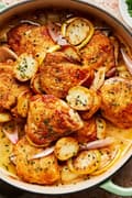 Braised chicken with potatoes and chive butter sauce in a braising dish