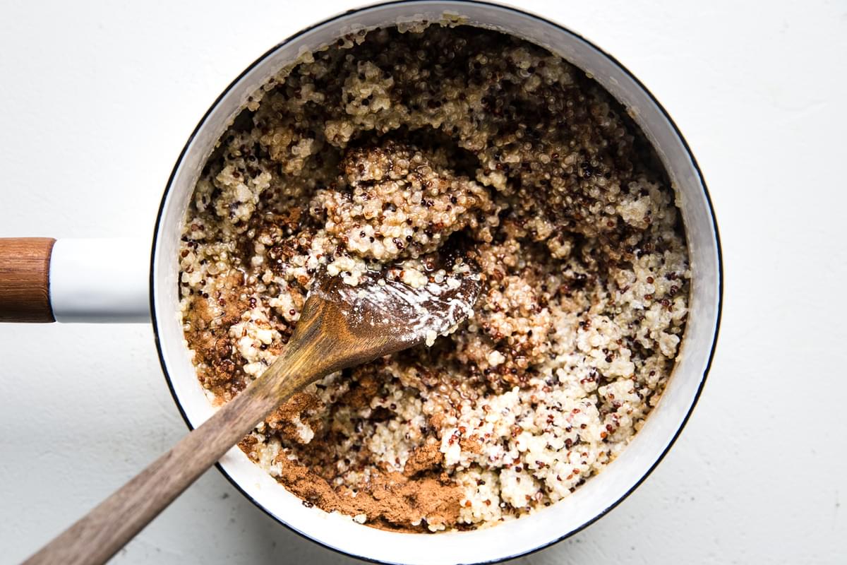 breakfast quinoa made with coconut milk, cinnamon, vanilla, and maple syrup in a small pot
