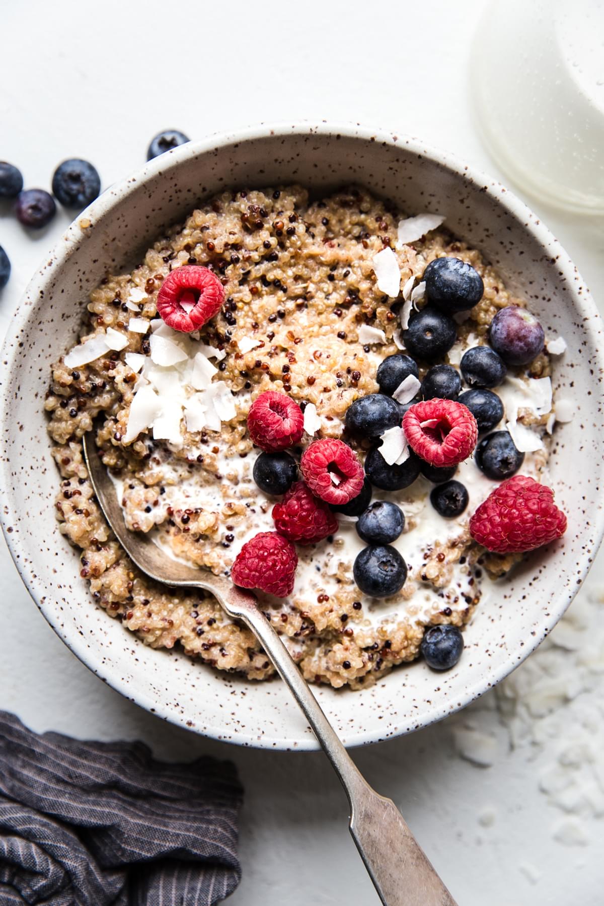 quinoa breakfast made with coconut milk, maple syrup, vanilla, salt and fresh berries in a bowl
