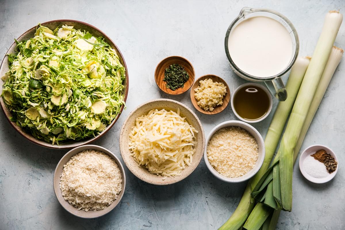 a bowl of shaved Brussels sprouts, heavy cream, 3 leeks, garlic, Parmesan, Gruyere cheeses and bread crumbs.