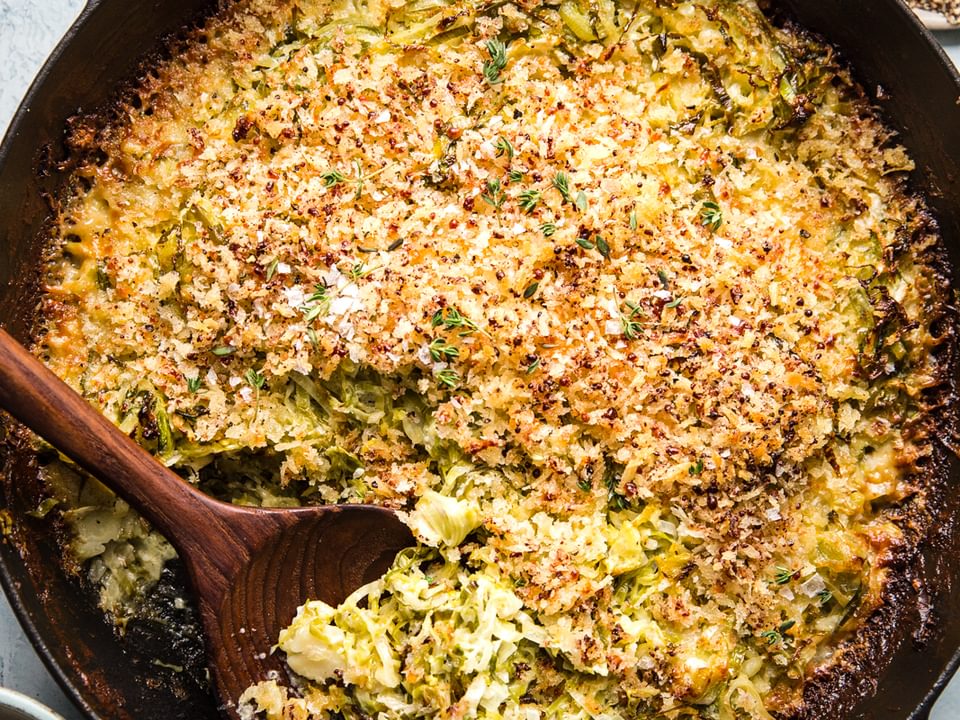 Brussels sprouts gratin with cream, garlic, Parmesan, Gruyère cheeses and toasted bread crumbs in a baking dish