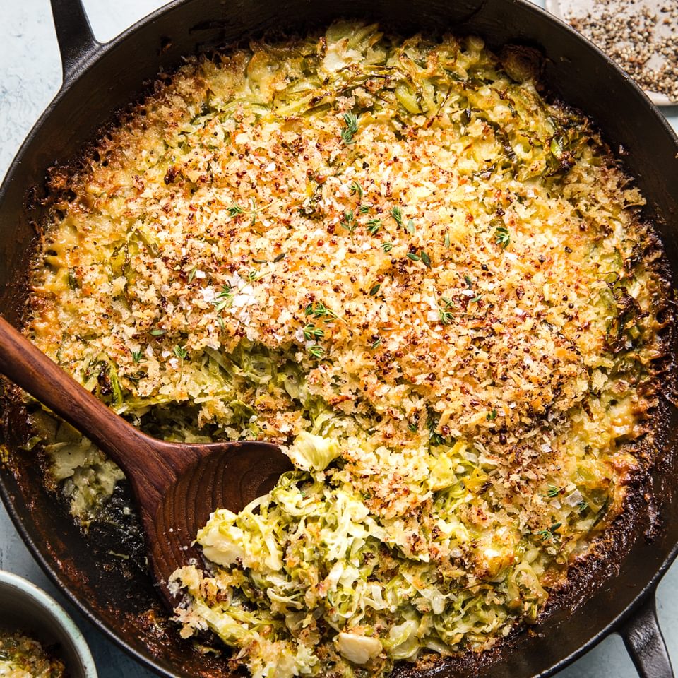 Brussels sprouts gratin with cream, garlic, Parmesan, Gruyere cheeses and toasted bread crumbs in a baking dish