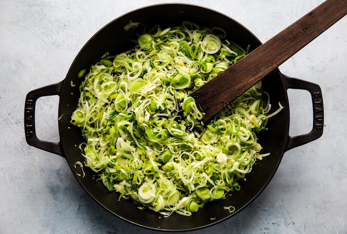 sautéed leeks and shaved brussels sprouts in a baking dish
