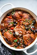 homemade chicken cacciatore recipe in a while pot with olives and tomatoes.