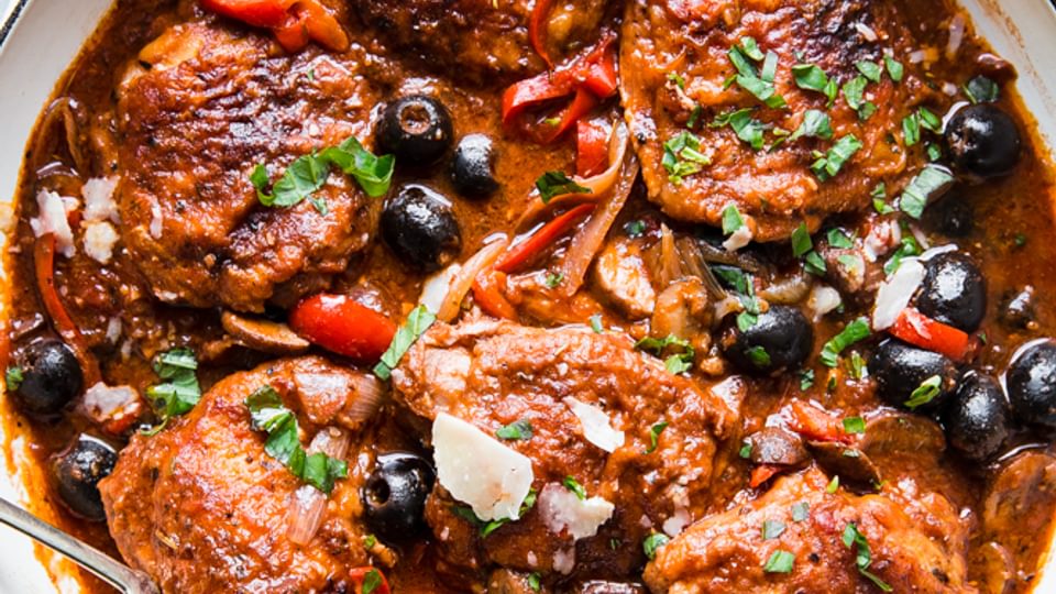 homemade chicken cacciatore recipe in a while pot with olives and tomatoes.
