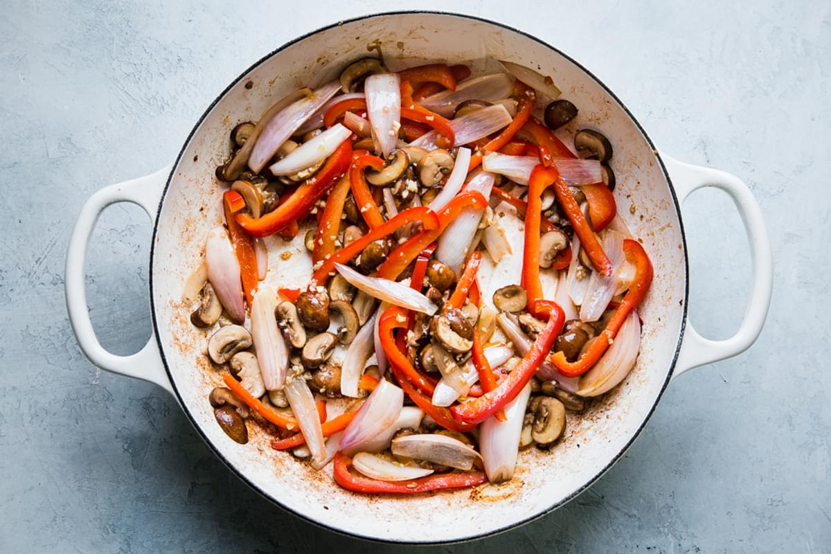 thinly slice shallots and bell peppers with mushrooms and garlic in a braiser pan
