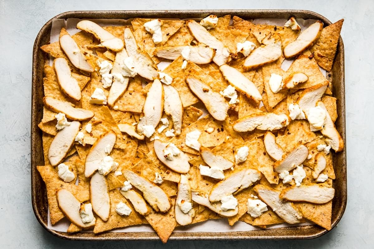 sheet pan of roasted shawarma chicken, and feta cheese over corn chips