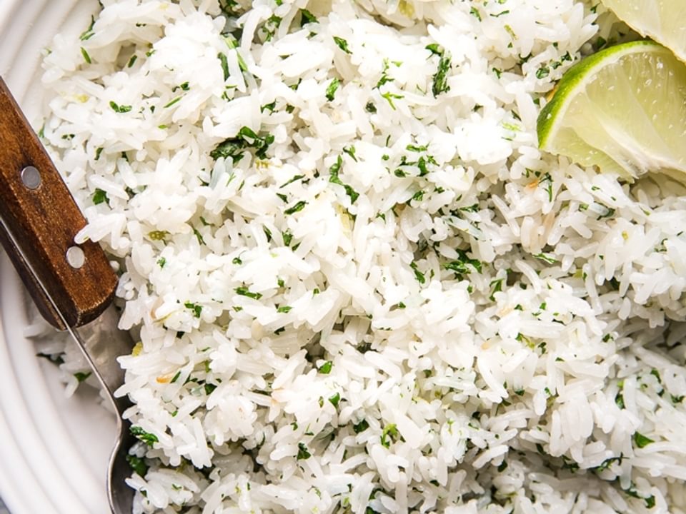 homemade cilantro lime rice in a bowl with a wooden spoon