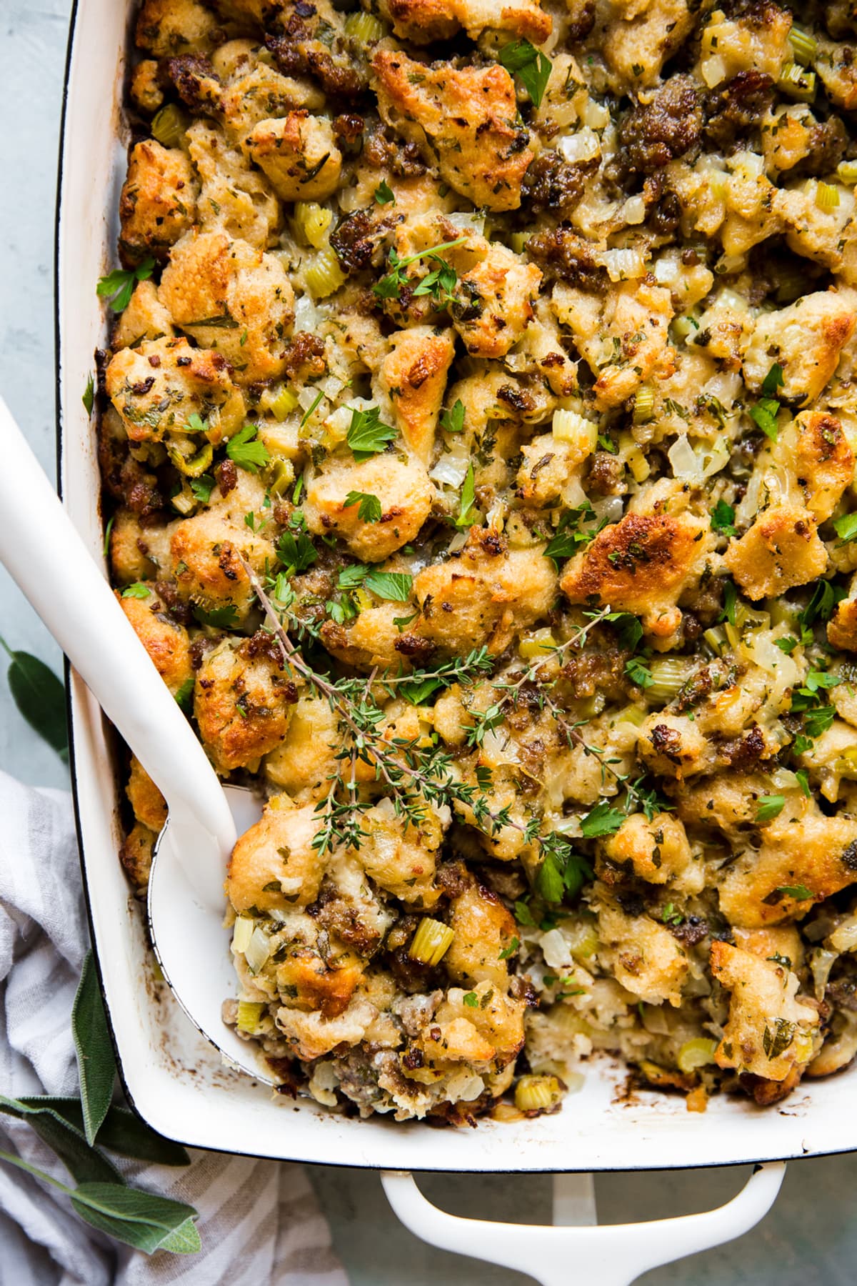 classic sausage stuffing in a baking dish with a serving spoon