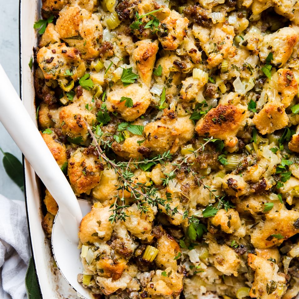 classic sausage stuffing in a baking dish with a serving spoon