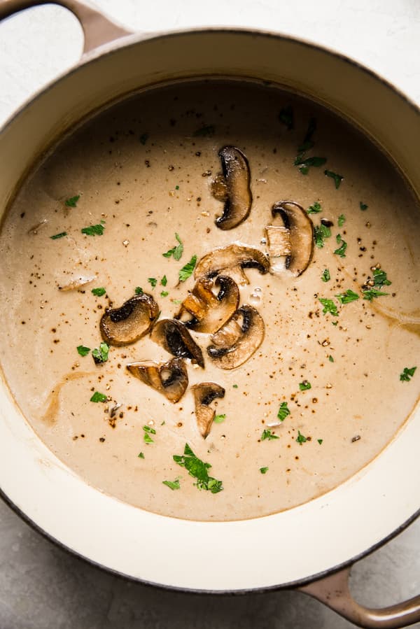 cream of mushroom soup in a soup pot with parsley