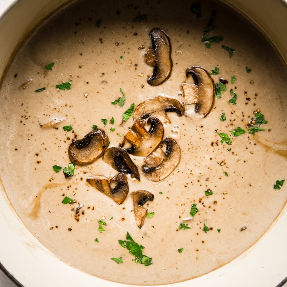 cream of mushroom soup in a soup pot with parsley