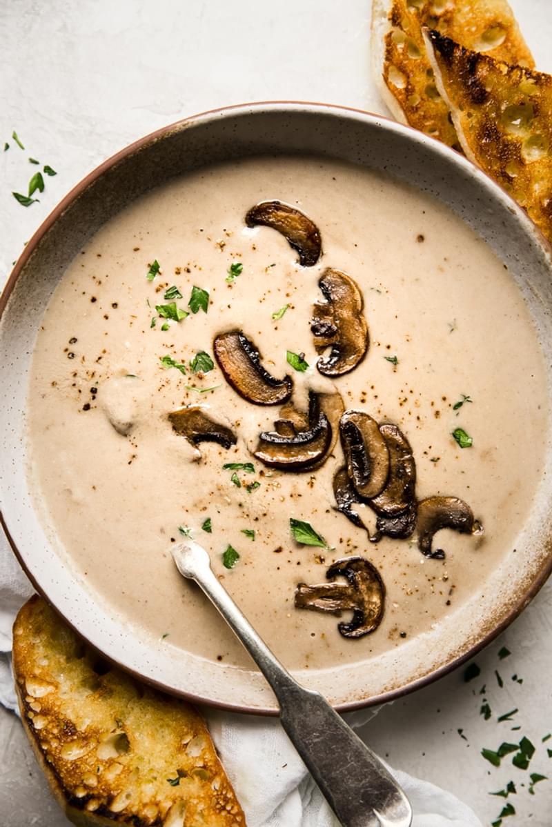 a bowl of homemade cream of mushroom soup served with crusty bread