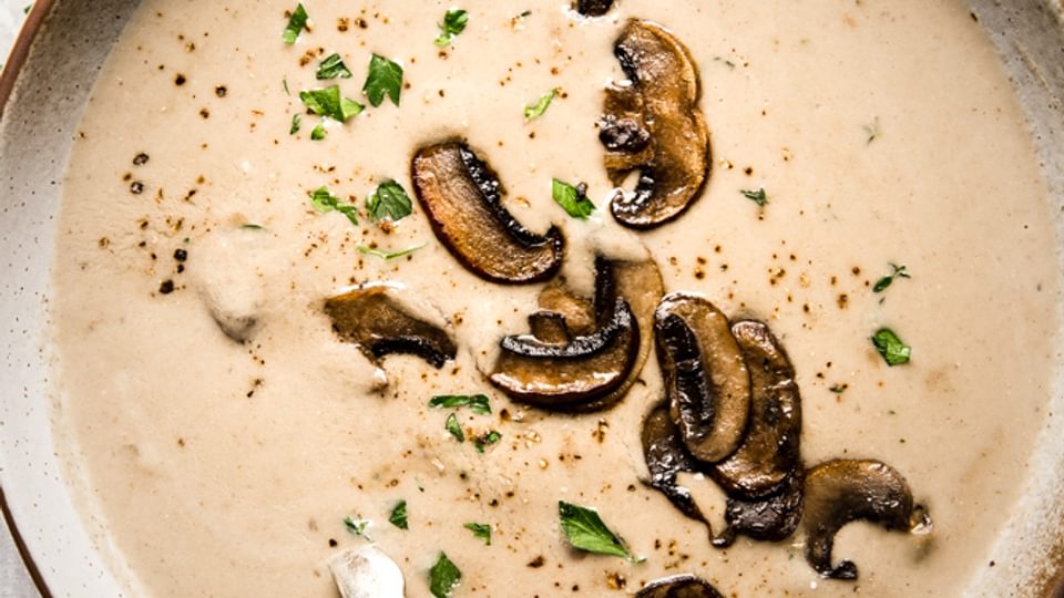 a bowl of homemade cream of mushroom soup served with crusty bread