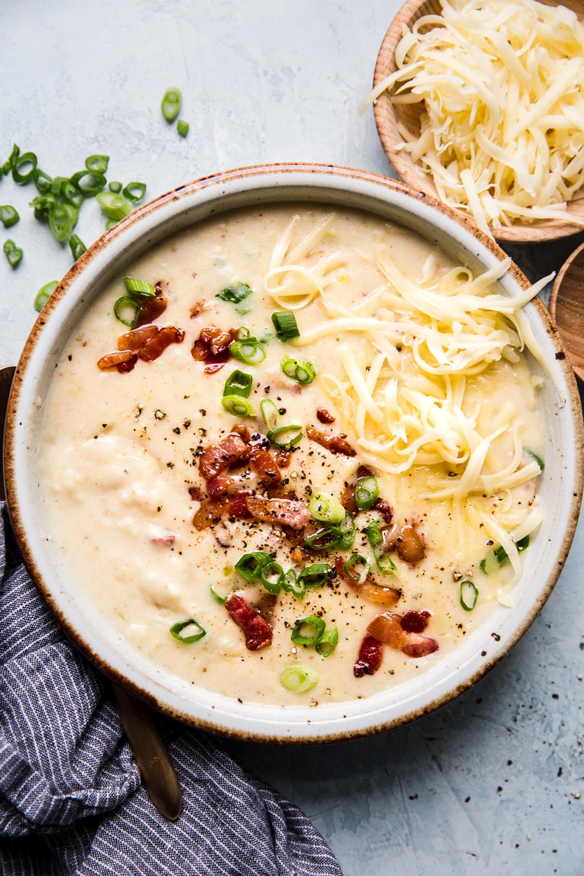 loaded potato soup with bacon, cheddar cheese and green onions in a bowl