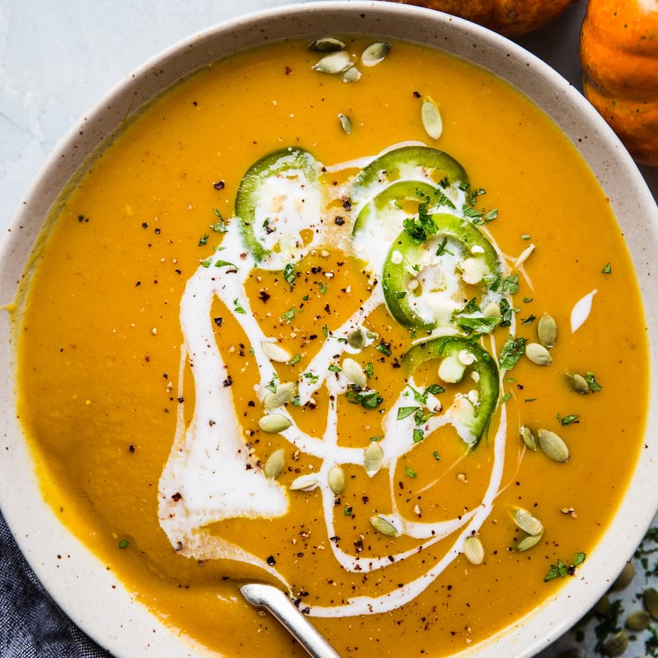 Curried pumpkin soup topped with pumpkin seeds, slivered jalapenos, and drizzled with coconut milk