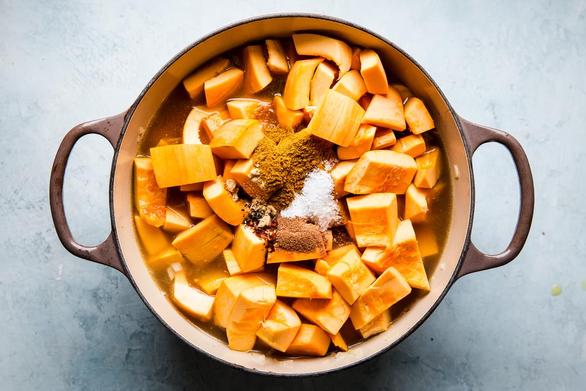 raw pumpkin, raw butternut squash and spices in a large soup pot