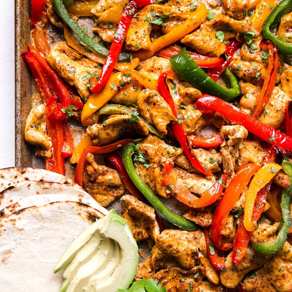 freezer chicken fajita meal on a sheet pan for dinner with tortillas and avocado and bell peppers