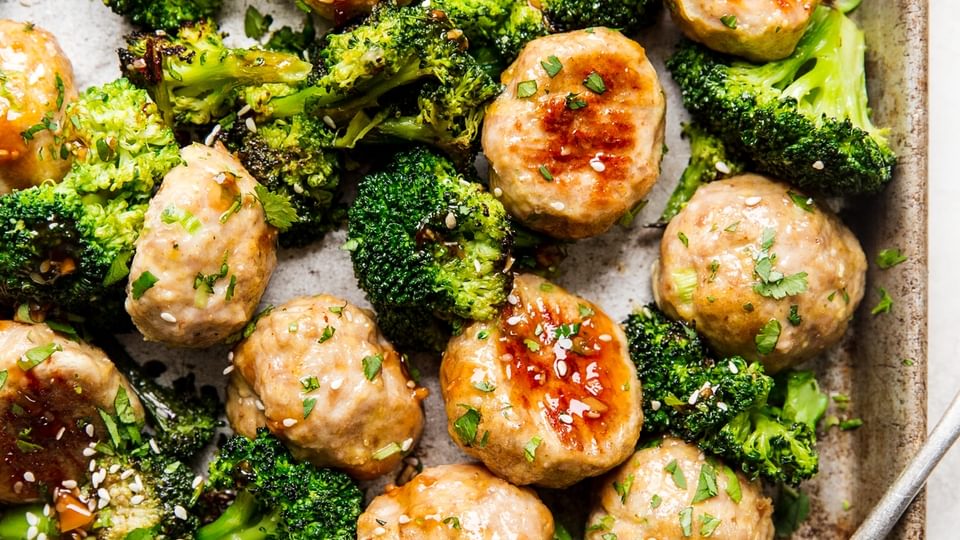 Freezer meal teriyaki chicken meatballs on a sheet pan with broccoli