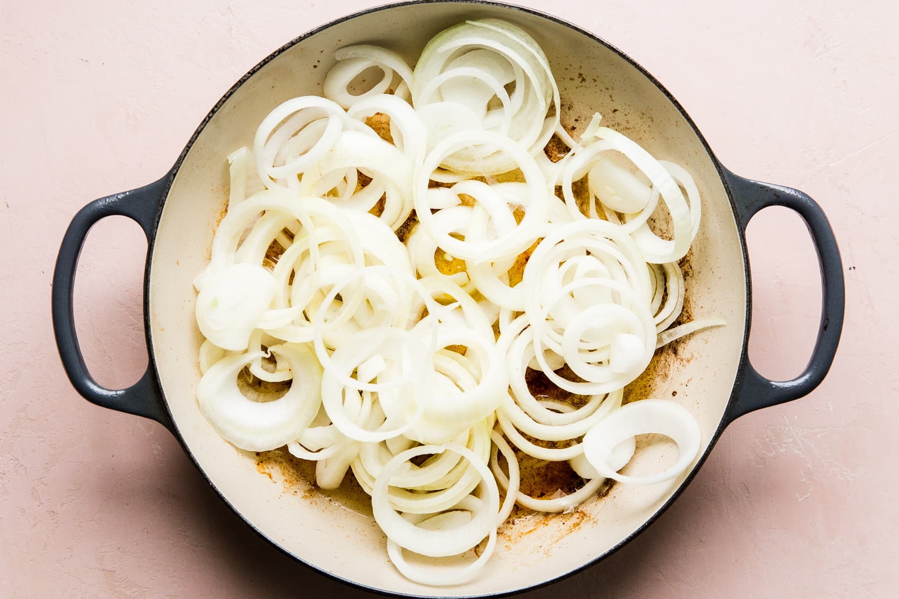 raw onions in a braiser ready to be caramelized