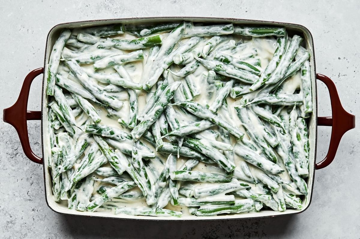 blanched green beans covered in homemade cream sauce in a casserole dish