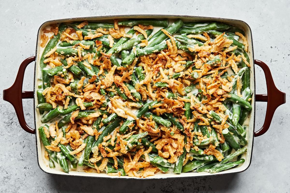 homemade green bean casserole with a creamy sauce and topped with French fried onions in a casserole dish