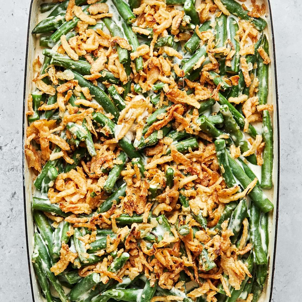 homemade green bean casserole with a creamy sauce, topped with French fried onions in a casserole dish