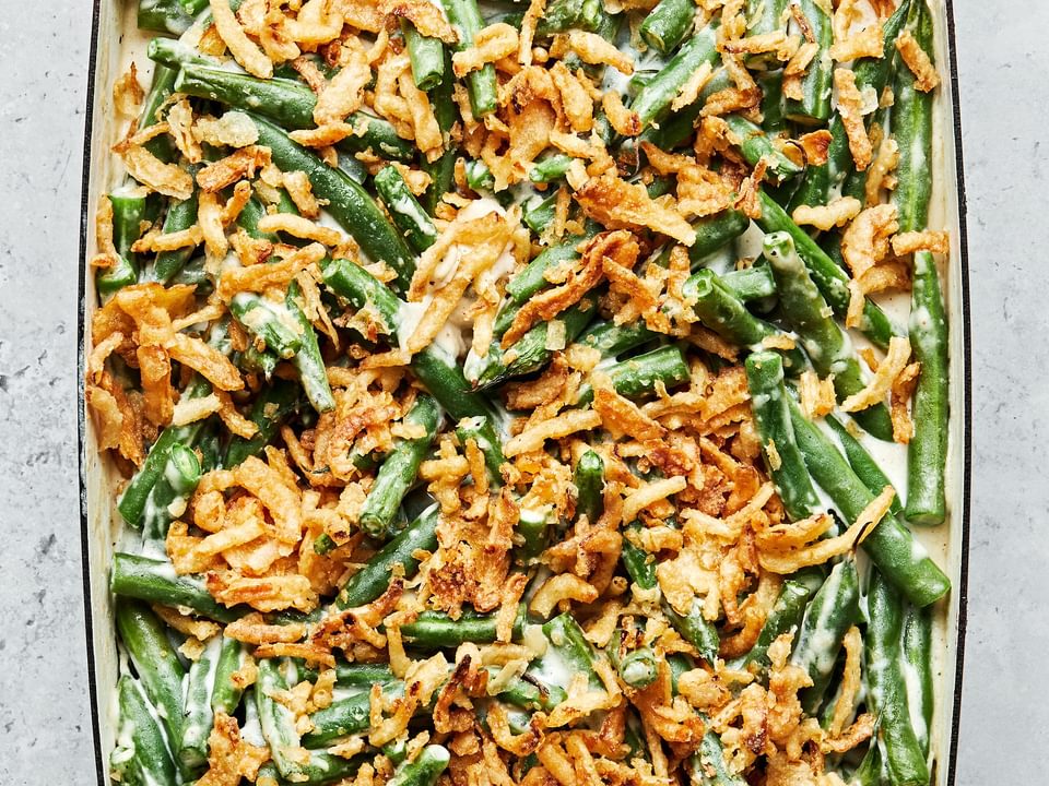 homemade green bean casserole with a creamy sauce and topped with French fried onions in a casserole dish