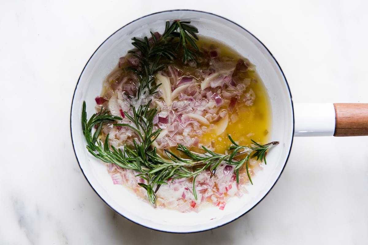 Melted butter, shallots, garlic and rosemary in a small white sauce pan.