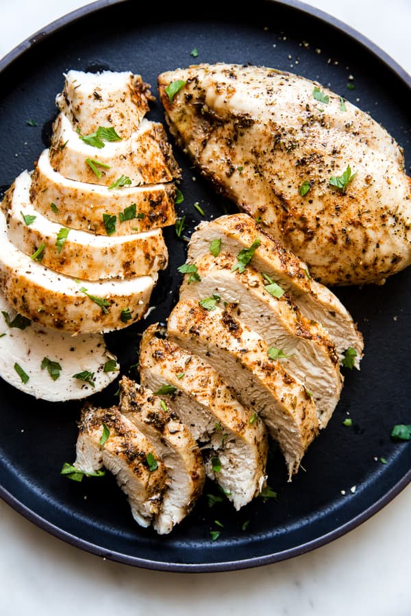 instant pot chicken that was cooked in the pressure cooker with seasoning on a black plate