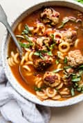 Italian tomato Meatball soup with basil and pasta in a bowl with a spoon