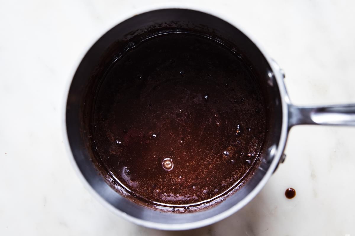 sugar, milk, butter and cocoa powder being simmered in a sauce pan for no-bake cookies