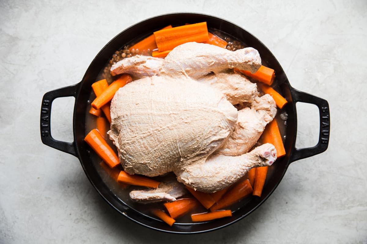 yogurt marinated chicken over lentils and carrots in a large skillet