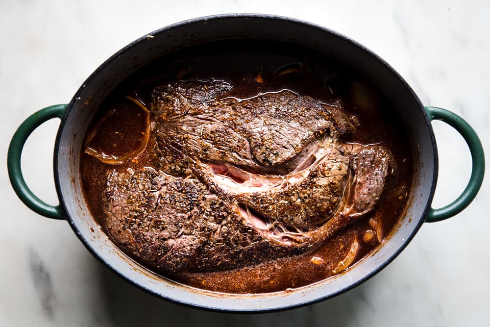 Browned chuck roast in red wine in a dutch oven.