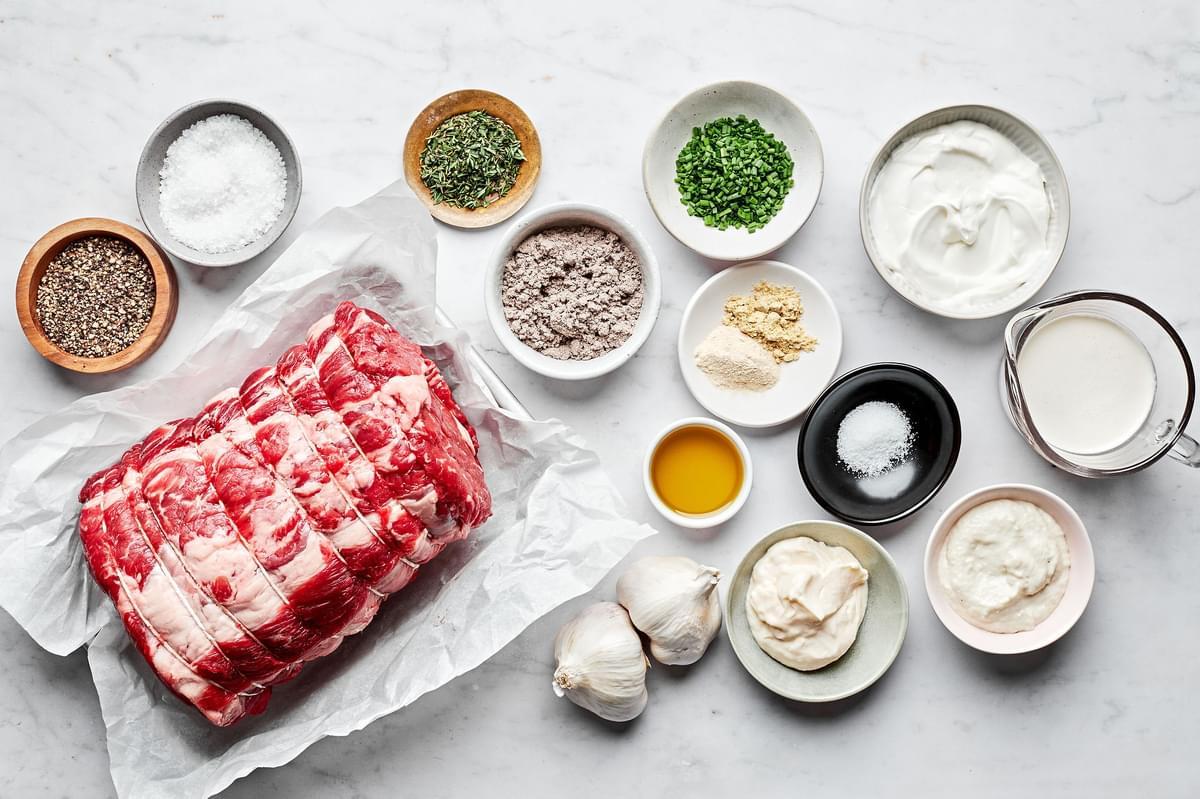 ingredients to make prime rib with roasted garlic and horseradish cream sauce in bowls on the counter