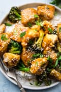 sesame chicken with broccoli and rice on a plate with a fork