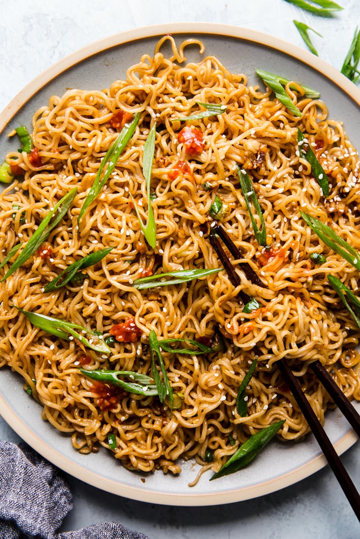 Sesame Garlic Noodles on a plate with garlic chili sauce