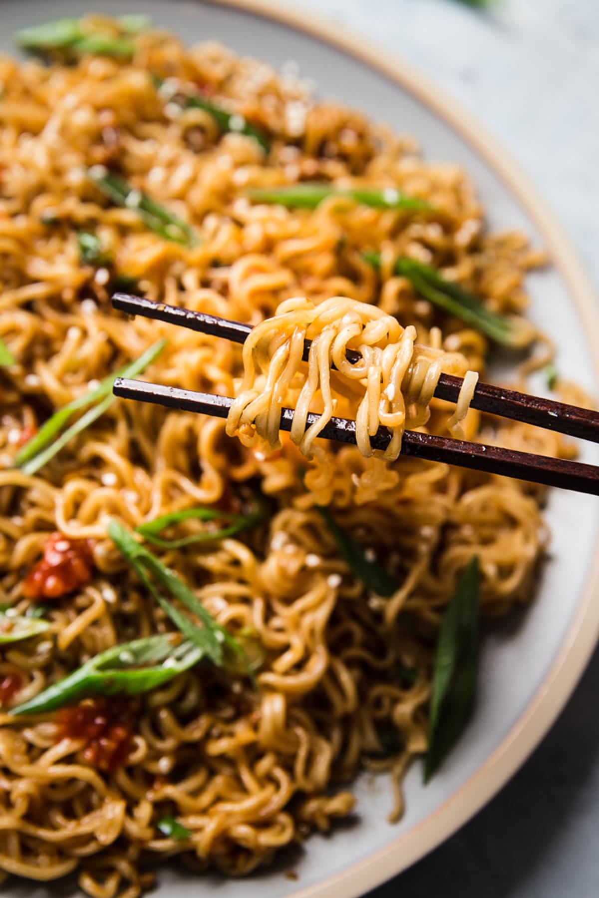 Sesame garlic ramen noodles on a plate with chopsticks