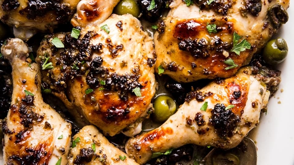 chicken marbella on a white platter with olives and dates
