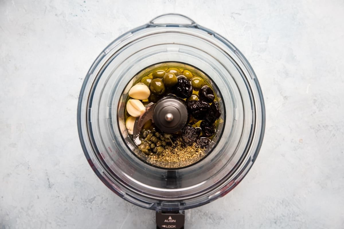 olives, herbs, capers, garlic in a food processor