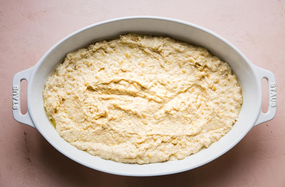 homemade spoon bread batter spread in a casserole dish that has been sprayed with non stick spray