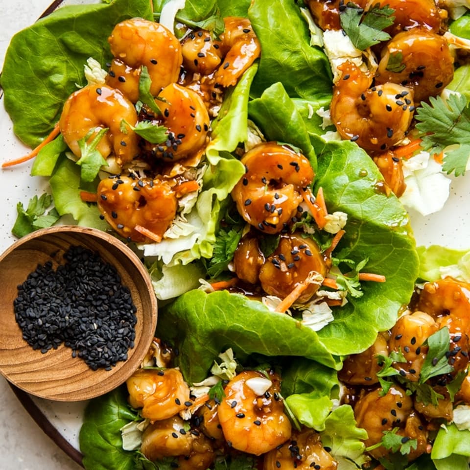honey garlic shrimp lettuce cups with sticky sweet marinated shrimp asian cabbage slaw in butter lettuce on a plate