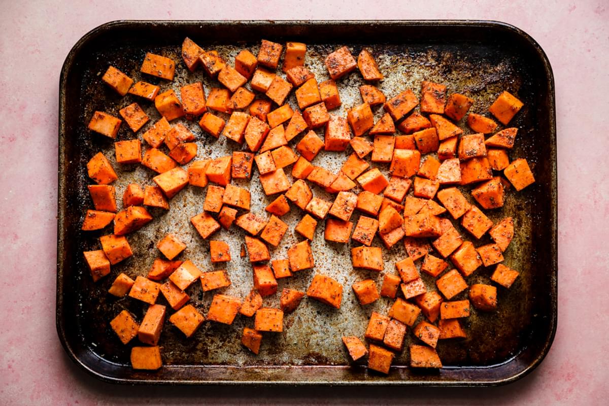 cubed sweet potatoes on a baking sheet with taco seasoning