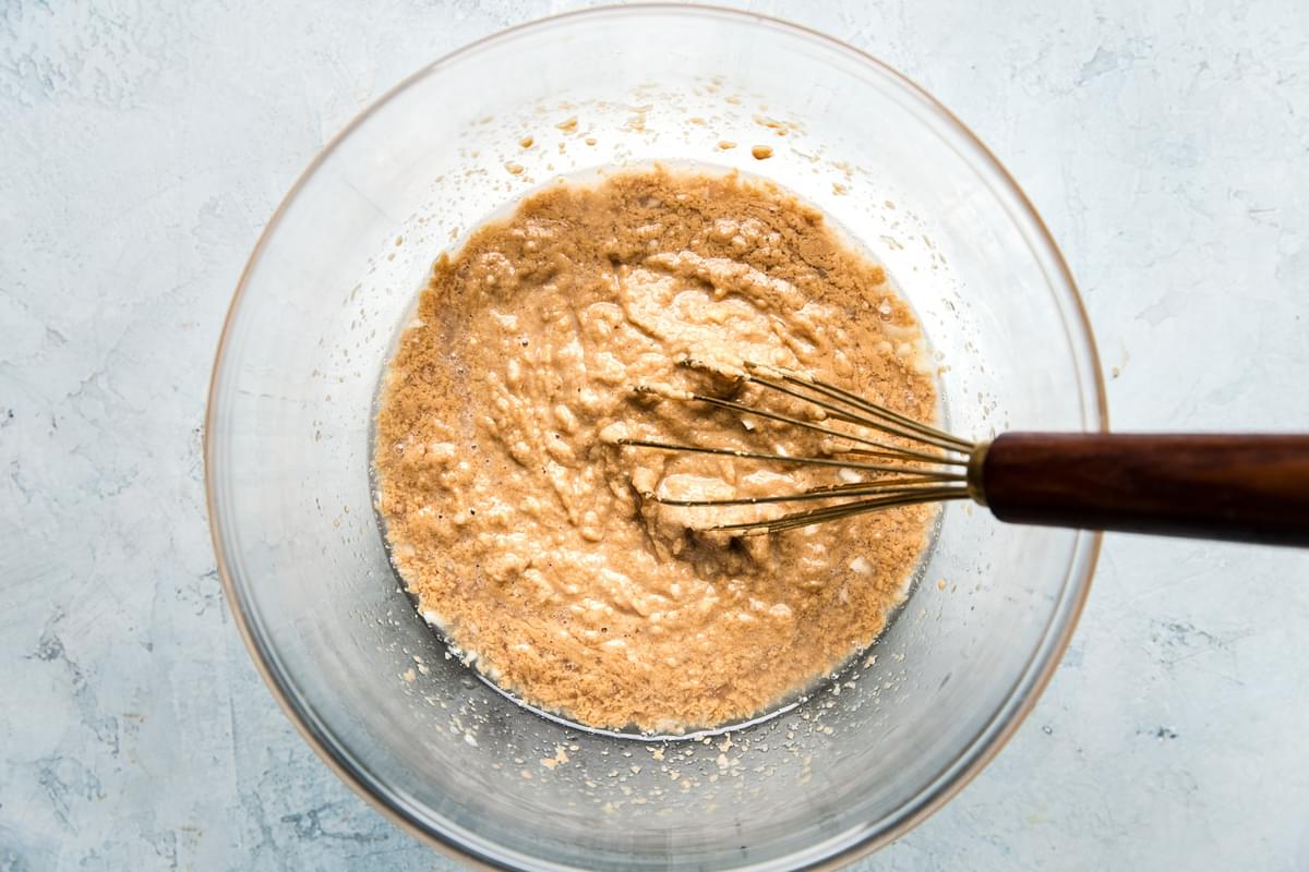 whisk stirring tahini sauce in a glass bowl