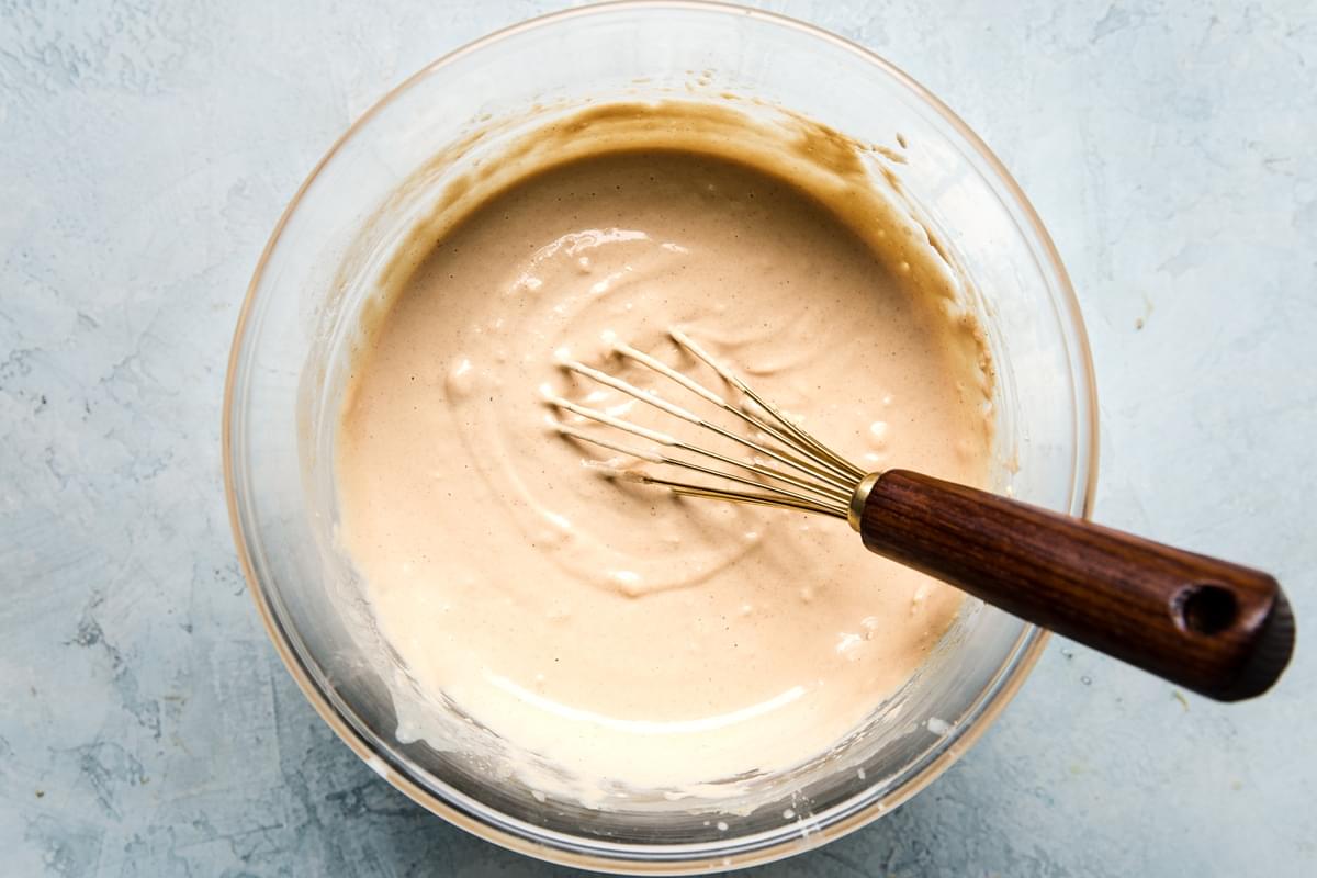 whisk in a glass bowl of homemade tahini sauce