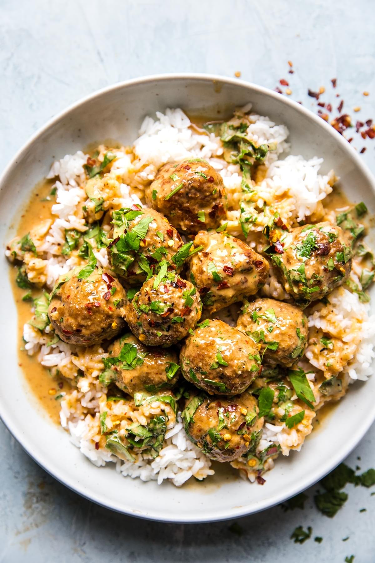 red curry turkey meatballs in a coconut curry sauce over white rice in a bowl