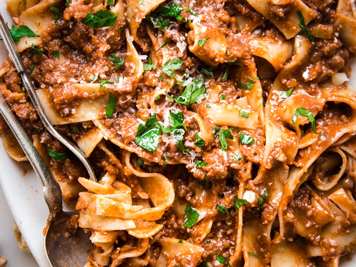 Walnut Vegan Bolognese with lentils with pasta on a plater with a serving spoon