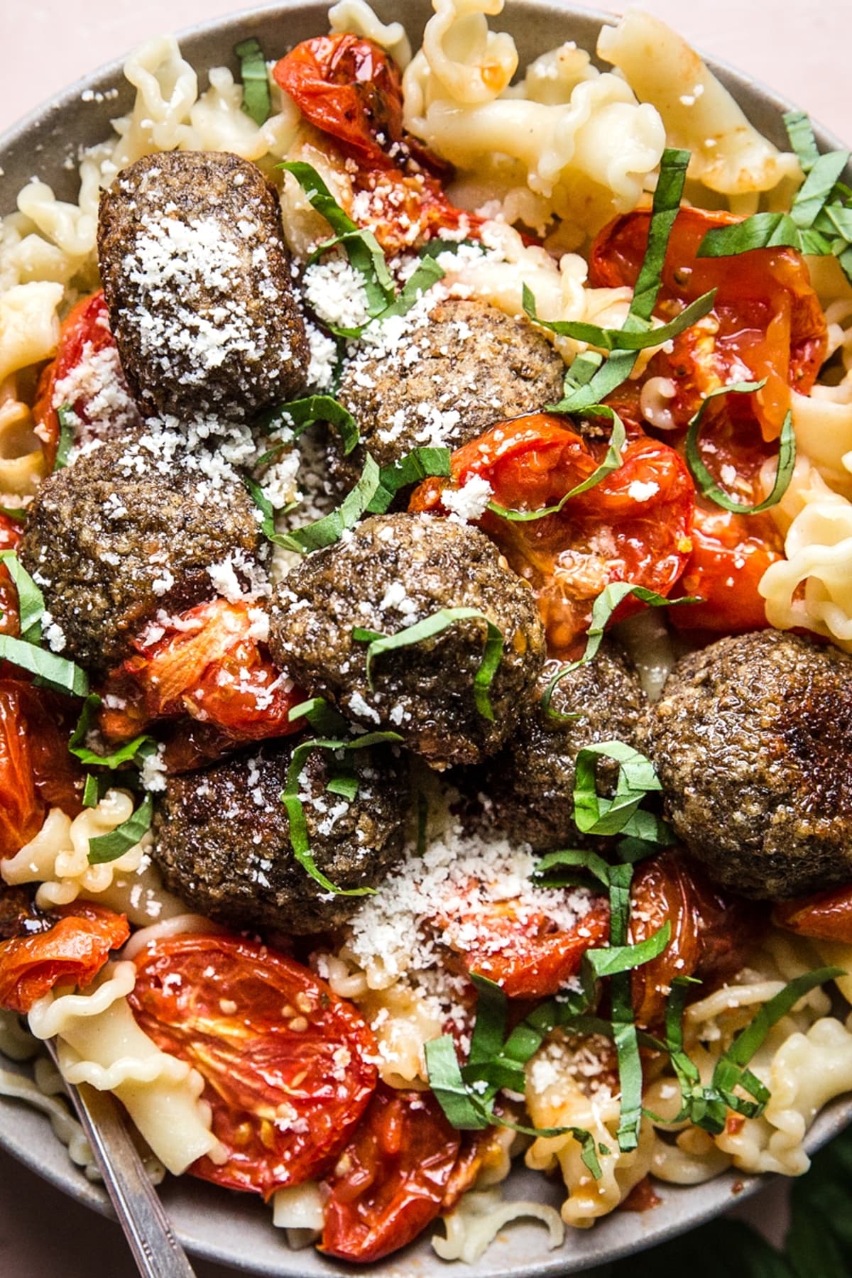 vegetarian meatballs in a bowl of pasta with roasted tomatoes.