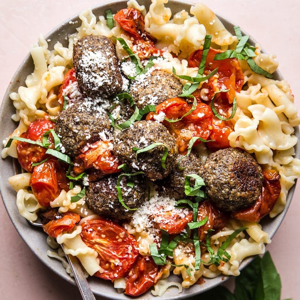 vegetarian meatballs in a bowl of pasta with roasted tomatoes.